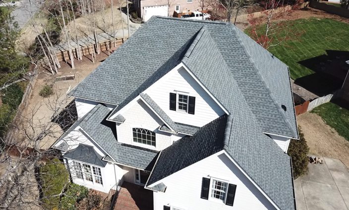Weatherguard Roofing & Restoration | White home with a new roof installled by Weatherguard Roofing and Restoration after damage was done by a storm