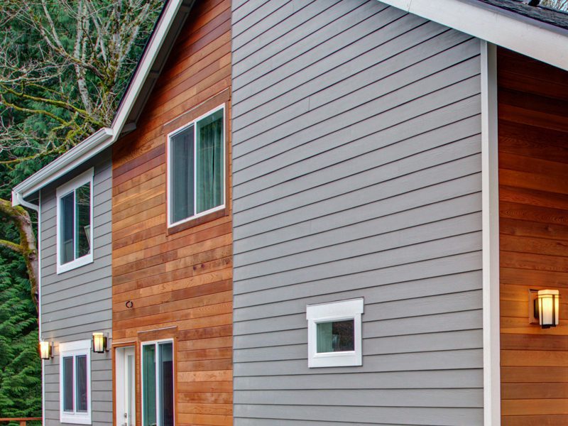 Weatherguard Roofing & Restoration | Freshly installed siding on a home surrounded by trees